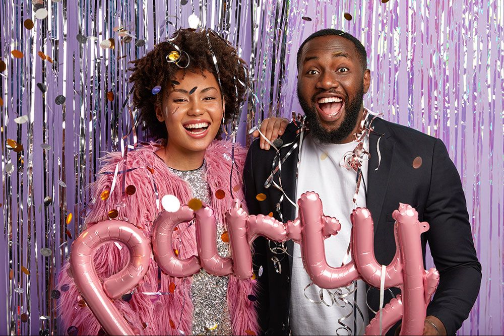 Smiling guests with 'party' balloons at a private celebration.